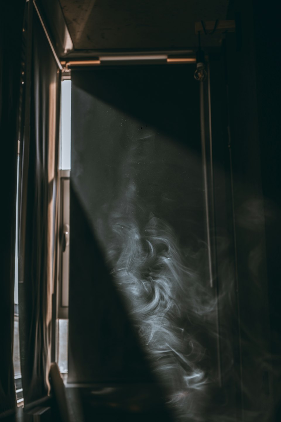 Sunlight streams into a dark room through a doorway.