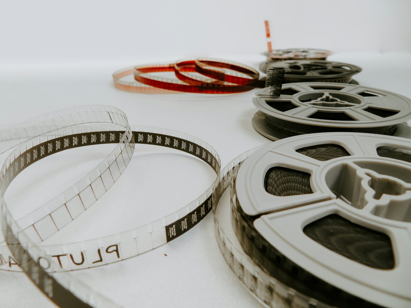 Vintage film reels and strips on a white surface.